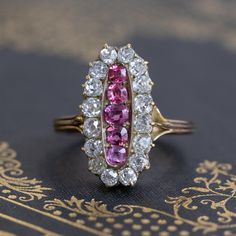 Total love at first sight! I just love everything about this ring - from the deep deep pink color of the natural pink sapphires to the chunky and rustic old mine cut diamond surround. But the best part is the oval silhouette of the ring - its just so elegant on the finger! The diamonds frame the sapphires beautifully, allowing the sapphires to pop against the bright diamonds. Size 6.75 and fully sizable.Measures 20.86 x 10.5mm across the face.1.80ctw of diamonds are J/K color, VS/SI1clarities (G Oval Pink Jewelry With Single Cut Diamonds, Pink Oval Jewelry With Single Cut Diamonds, Oval Ruby Cluster Ring With Rose Cut Diamonds, Pink Ruby Ring With Single Cut Diamonds, Oval Ruby Ring With Rose Cut Diamonds, Pink Ruby Ring With Rose Cut Diamonds, Antique Pink Rose Cut Diamond Rings, Oval Ruby Rings With Single Cut Diamonds, Pink Oval Rings With Rose Cut Diamonds