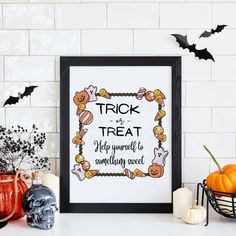 a framed halloween poster on a table with pumpkins