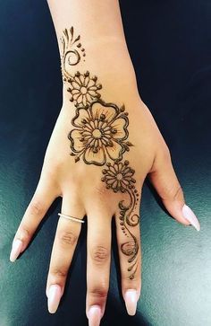 a woman's hand with henna tattoos on it