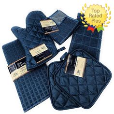 blue towels and oven mitts are laid out on a white surface with gold tags