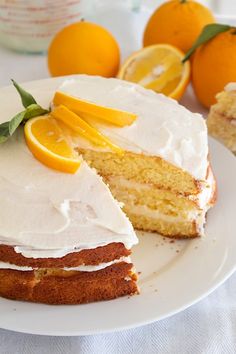 a piece of cake with white frosting and oranges around it on a plate