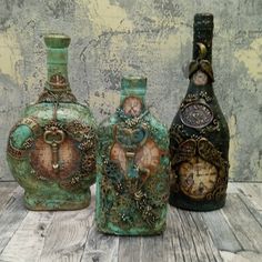 three vases sitting next to each other on top of a wooden table in front of a wall