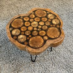 a coffee table made out of tree trunks on top of a carpeted floor with metal legs