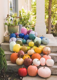 pumpkins and gourds sitting on the steps in front of a house