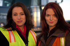 two women in safety vests standing next to each other