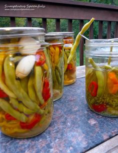 jars filled with pickled vegetables sitting on top of a table