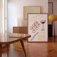 an art work is displayed in front of a coffee table and lamp on a wooden floor