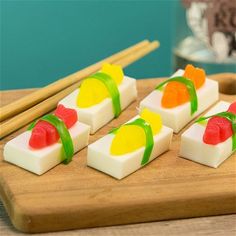 small pieces of sushi on a cutting board with chopsticks