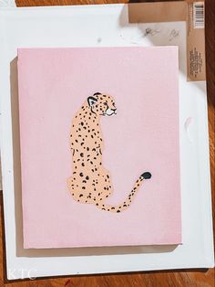 a painting of a cheetah sitting on top of a piece of pink paper