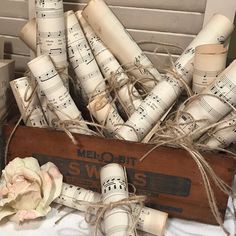 a wooden box filled with lots of musical paper rolls and a flower next to it