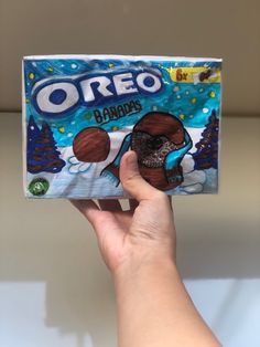 someone holding up a box of oreo candies in their left hand, with an image of a bear on it