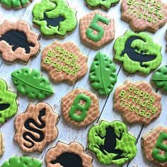 cookies decorated with green and black icing on a table top, including the number six