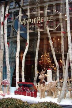 a store window with fake trees and deer statues