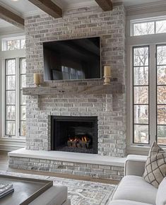 a living room filled with furniture and a flat screen tv mounted on the wall above a fire place