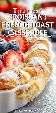 the best croissant french toast casserole is topped with fresh berries and powdered sugar