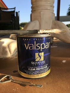 a can of paint sitting on top of a table next to a pair of scissors