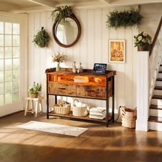 a wooden table sitting in the middle of a living room next to a stair case