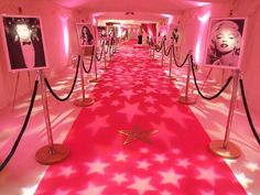 a long hallway with red carpet and pictures on the walls