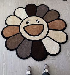 a person standing on the floor in front of a rug with a turkey face drawn on it