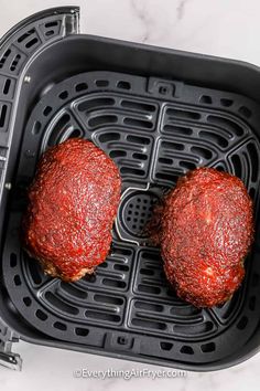 two hamburger patties in an air fryer