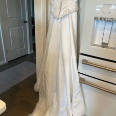 a white wedding dress hanging on the wall