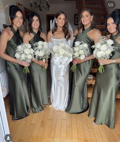 a group of women standing next to each other holding bouquets