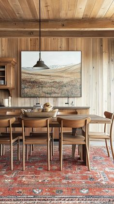 a dining room table with chairs and a painting hanging on the wall above it's wooden paneling