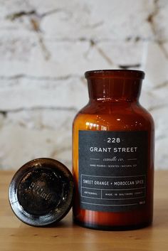 a candle and wax seal sitting on a wooden table next to a white brick wall