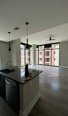 an empty kitchen and living room with large windows