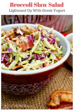 a bowl filled with coleslaw and bacon next to toasted baguettes