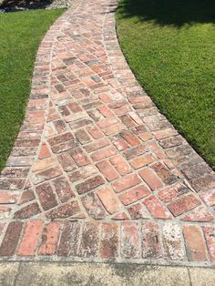 a brick path in the middle of a grassy area