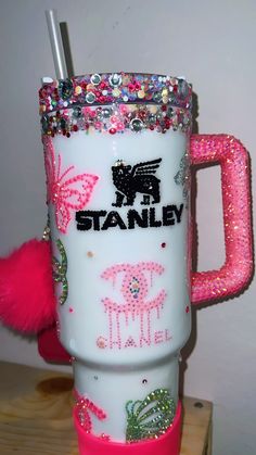 a pink and white coffee cup with the name stanley on it's side