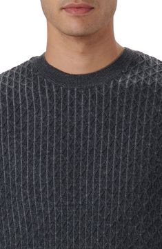 a man wearing a gray sweater and glasses