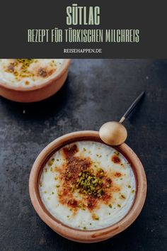 two small bowls filled with food on top of a table next to a wooden spoon