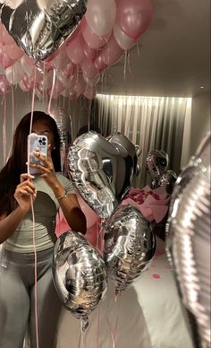 a woman taking a selfie in front of balloons