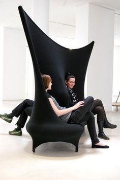 two women sitting on chairs in an empty room