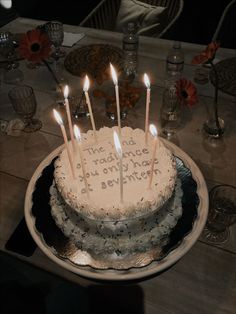 a birthday cake with lit candles sitting on a table