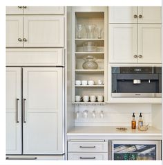 a kitchen with white cabinets and silver appliances