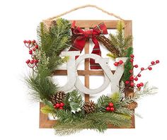 a wooden sign with the word joy hanging from it's side, decorated with evergreen and red berries