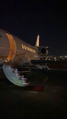 an airplane sitting on the tarmac at night