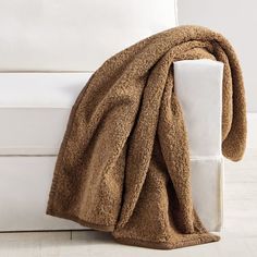 a brown blanket sitting on top of a white couch