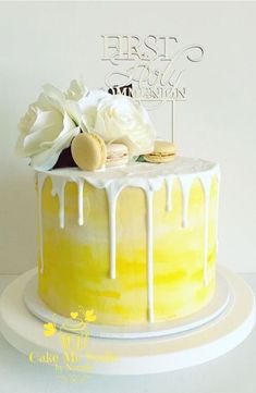 a yellow cake with white icing and flowers on top