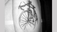 a black and white photo of a man's arm with a bicycle tattoo on it