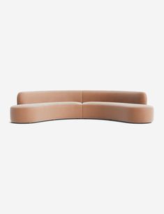 the curved sectional sofa is made out of leather and has a light brown color scheme