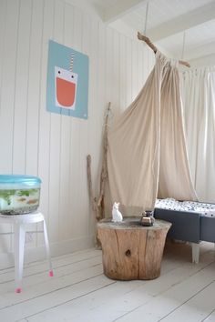 a room with a bed, table and chair in it on the white wood floor