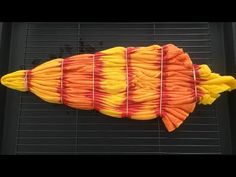 an orange and yellow fish shaped cake sitting on top of a grill