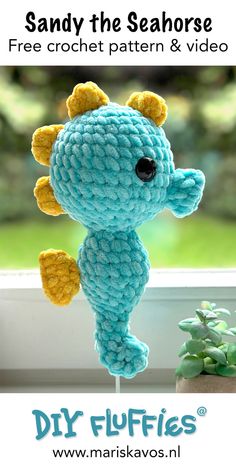 a blue crocheted stuffed animal sitting on top of a window sill next to a potted plant