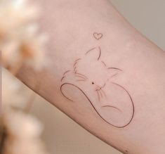 a small tattoo on the arm of a person with a cat in it's head