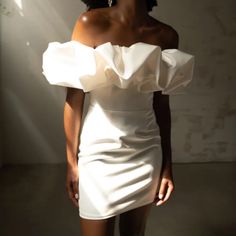 a woman in a white dress posing for the camera