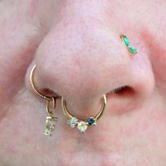 a close up of a person's nose with two piercings on their nose